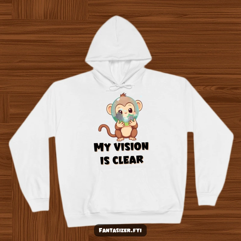 Funny Monkey Hoodie: Adorable primate holding a crystal ball that reveals a secret fantastical landscape, a warm and funny gift.